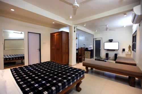 a bedroom with a bed and a flat screen tv at Yash Villa - Studio Apatrment Villa in Panchgani