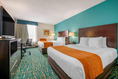 a hotel room with two beds and a flat screen tv at Comfort Inn & Suites Fort Lauderdale West Turnpike in Fort Lauderdale