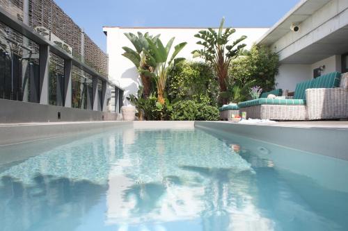 a swimming pool with a pool table and chairs at Ofelias Hotel 4* Sup in Barcelona