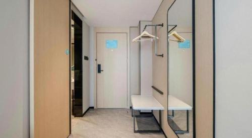 a dressing room with a mirror and a bench at City Comfort Inn Nanning Guangxi University in Nanning