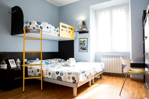 1 dormitorio con litera y paredes azules en Chat&Chill Vatican Apartment, en Roma