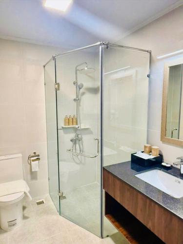 a bathroom with a glass shower and a sink at Lâm Viên Hotel & Retreat in Tinh Bien