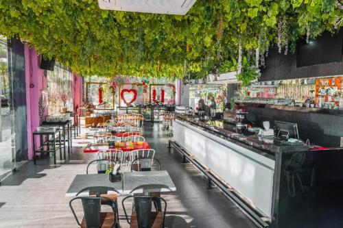 a restaurant with tables and chairs and a bar at G Suites Hotel By AMITHYA in Surabaya
