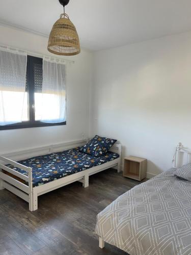 a bedroom with two beds and a window at Maison Romarin in Le Boulou
