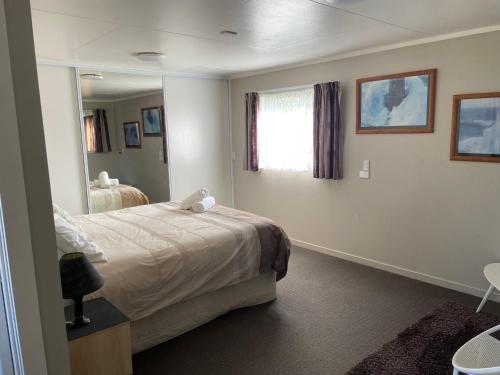 a bedroom with a bed and a large mirror at Quiet & Close to Town in Taupo