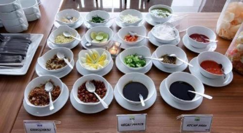 a table topped with bowls and plates of food at Asoka Luxury Hotel in Bandar Lampung