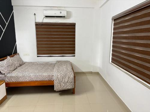 ein kleines Zimmer mit einem Bett und einem Fenster in der Unterkunft HR Mukkali in Attappādi