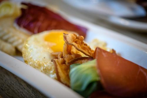 a plate of food with an egg and fries at Tirano stazioni flow rooms in Tirano