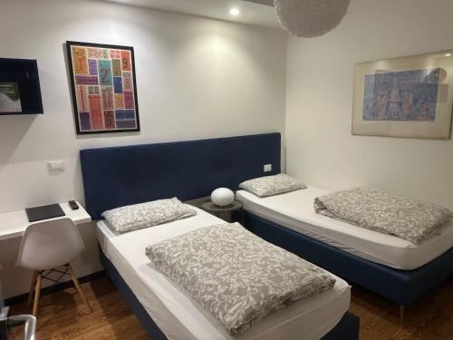 a room with two beds and a table and a desk at Tirano stazioni flow rooms in Tirano
