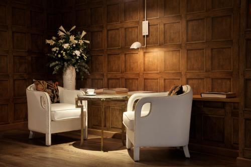 a room with a table and two chairs and a vase with flowers at Ofelias Hotel 4Sup in Barcelona