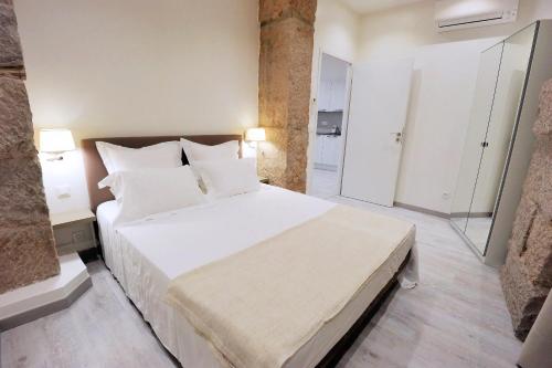 ニースにあるル 10 ニース マッセナのベッドルーム1室(大型ベッド1台、白いシーツ、枕付)