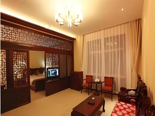 a living room with a couch and a television at Wutaishan Wufeng Hotel in Wutai