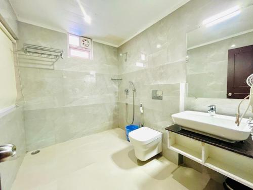a white bathroom with a sink and a toilet at The Continental Near Mg Marg in Gangtok