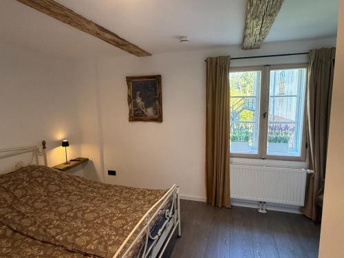 ein Schlafzimmer mit einem Bett und einem Fenster in der Unterkunft Müllerstube im historischen Müllerhaus in Lübeck
