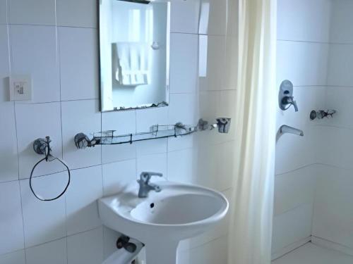 a white bathroom with a sink and a mirror at Hotel Norbu Sangpo in Kathmandu