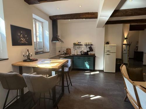 eine Küche mit Holztisch und Kühlschrank in der Unterkunft Müllerstube im historischen Müllerhaus in Lübeck