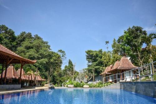 a swimming pool at a resort with trees in the background at VillaTel Salse in Bandung