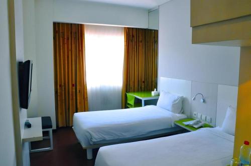 a hotel room with two beds and a television at Everbright Ambon Hotel in Ambon