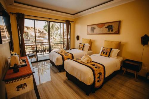 a hotel room with two beds and a balcony at Keep Diving Resort Bohol in Panglao