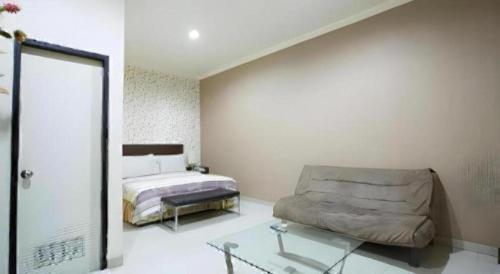 a bedroom with a bed and a glass table at Vindhika Hotel in Makassar