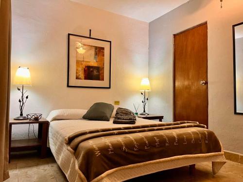 a bedroom with a bed with two tables and two lamps at Hotel 305 in Parras de la Fuente