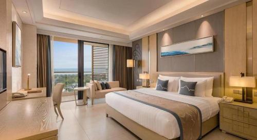a large bedroom with a large bed and a living room at Sanya Tibet Hotel in Sanya