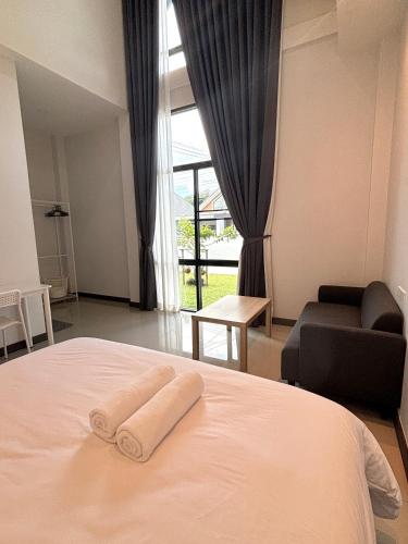 a bedroom with a bed with two towels on it at D sleep Villa Chiangmai in Chiang Mai