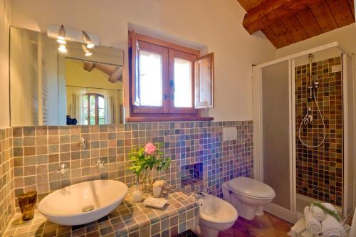 een badkamer met een wastafel, een toilet en een spiegel bij B&B Cristina in Porto Recanati