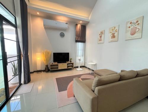 a living room with a couch and a tv at D sleep Villa Chiangmai in Chiang Mai
