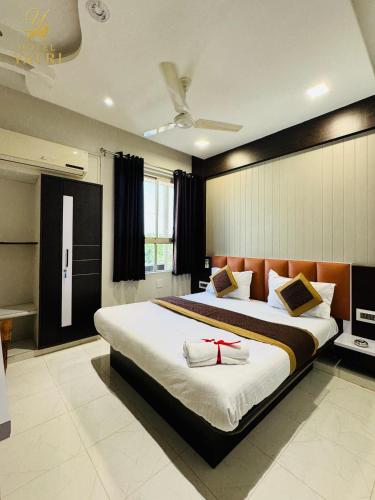 a bedroom with a large bed with a red ribbon on it at Hotel Yatri in Gandhinagar