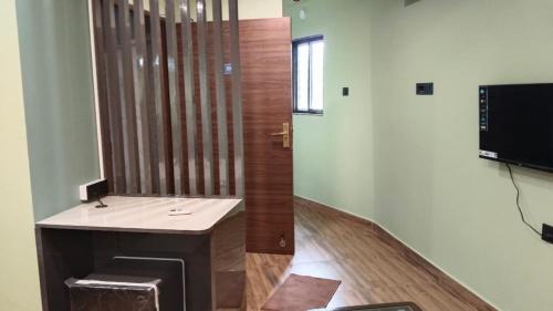 a bathroom with a sink and a television in a room at Hotel Ratnadurga in Ratnagiri