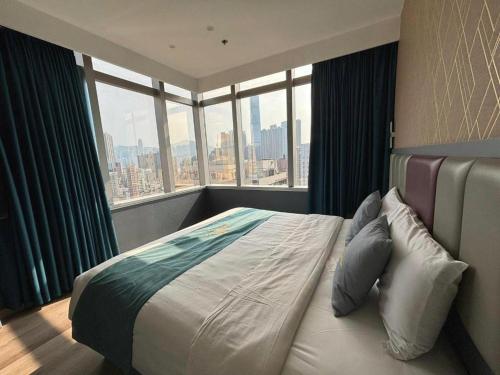 a bedroom with a bed with a large window at Metro Winner Hotel in Hong Kong