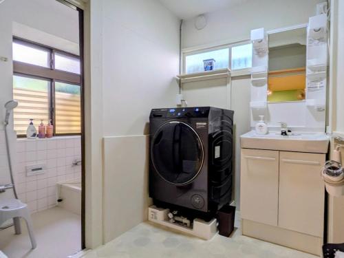 a kitchen with a washing machine in the corner of a room at サマサマアイル saMa-saMa Aisle in Odawara