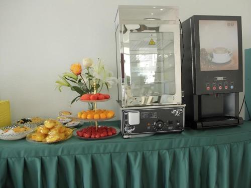 a table with a microwave and some food on it at Vatica Tianjin Jinghai Bus Station Home World Plaza Hotel in Tianjin