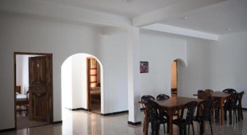 a dining room with a wooden table and chairs at Hotel Glee in Trincomalee