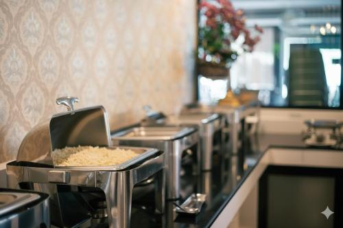 een keuken met een aanrecht met een spoelbak en etenswaren bij Phornpailin Riverside Resort in Sangkhla Buri