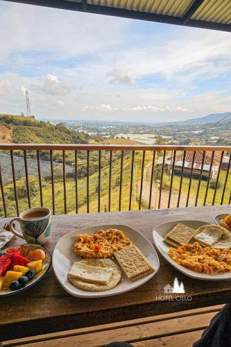 uma mesa com três pratos de comida numa varanda em Eco Parque Hotel & Glamping El Cielo El Carmen de Viboral em San Isidro