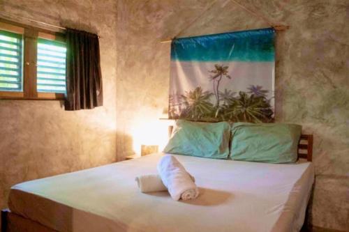 a bedroom with a bed with a towel on it at Sea Esta Cruz Siargao in General Luna