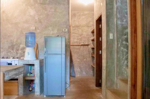 a kitchen with a blue refrigerator in a room at Sea Esta Cruz Siargao in General Luna