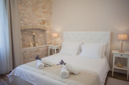 a bedroom with a white bed with towels on it at Barone Room in Šibenik