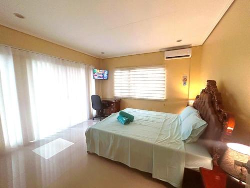 une chambre avec un lit et une télévision dans l'établissement Pelaez house in the bogo, à Bogo