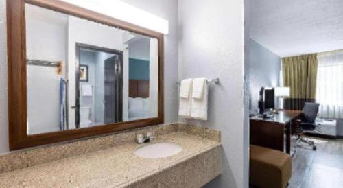 a bathroom with a sink in a hotel room at Travelodge by Wyndham Brooklyn Center in Minneapolis