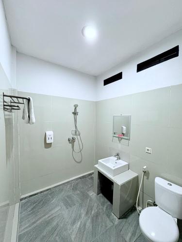 a bathroom with a shower and a toilet and a sink at La Colina Komodo Hotel in Labuan Bajo