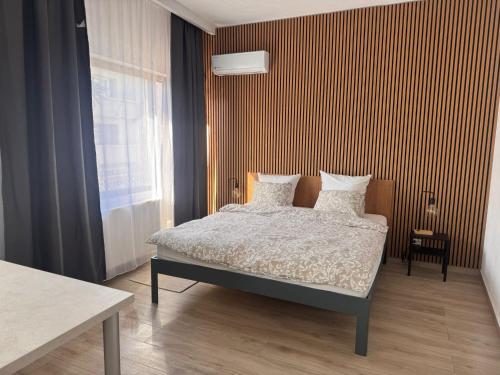 a bedroom with a bed and a striped wall at AT Modern Boutique in Bucharest