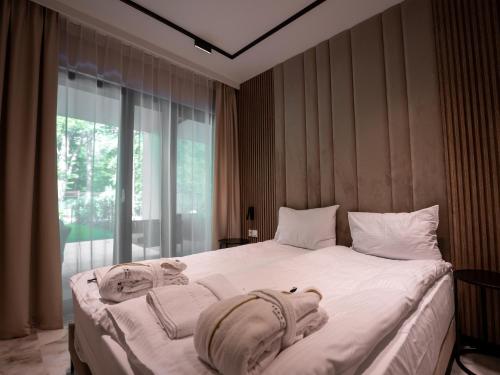 ein Schlafzimmer mit einem großen weißen Bett mit Handtüchern darauf in der Unterkunft Sea & Forest Resort Międzyzdroje in Misdroy