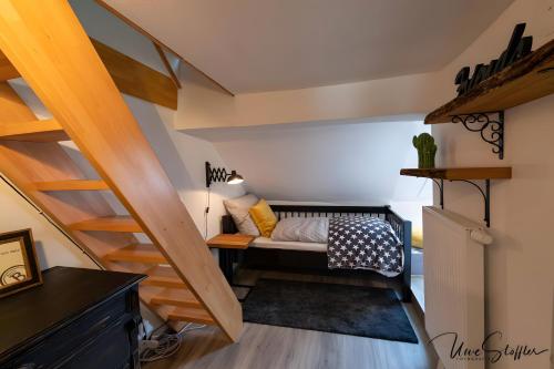 a small room with a couch under the stairs at Ferienwohnung Snug und Hugley in Neuenstein