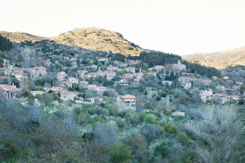 a town on a hill with trees and mountains at Elova in Zátouna