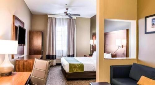 a hotel room with a bed and a couch at Hawthorn Extended Stay by Wyndham Amarillo in Soncy