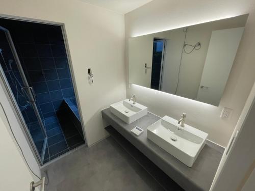 ein Badezimmer mit zwei Waschbecken und einem großen Spiegel in der Unterkunft アトレチア祇園宇治別邸プレミアム in Uji