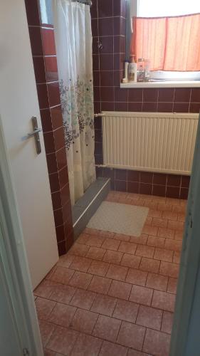 baño con ducha y suelo de baldosa. en Neron, en Grębocin